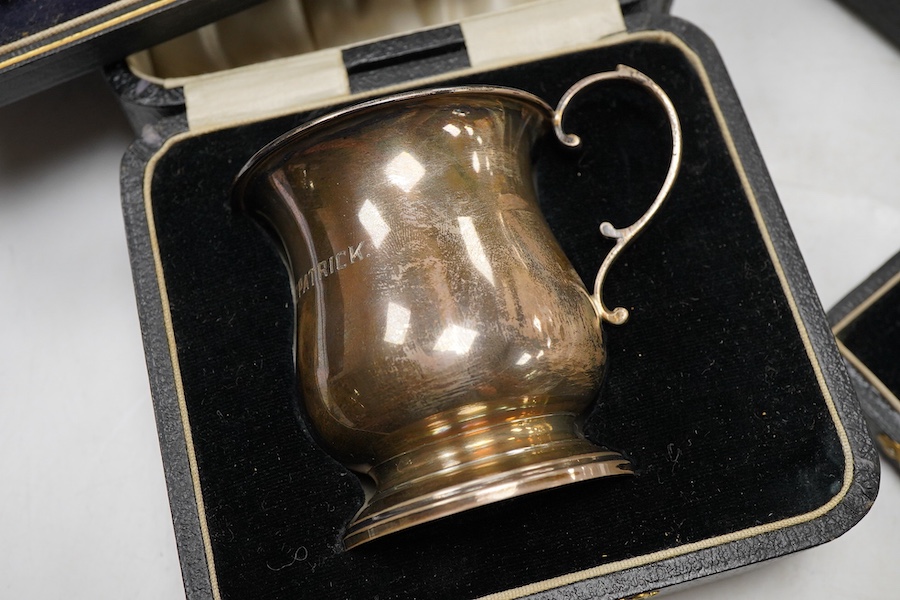 Four assorted cased silver sets including two handled christening bowl and spoon, Birmingham, 1934, a similar christening mug, set of six teaspoons with sugar tongs and six George V lobster picks.